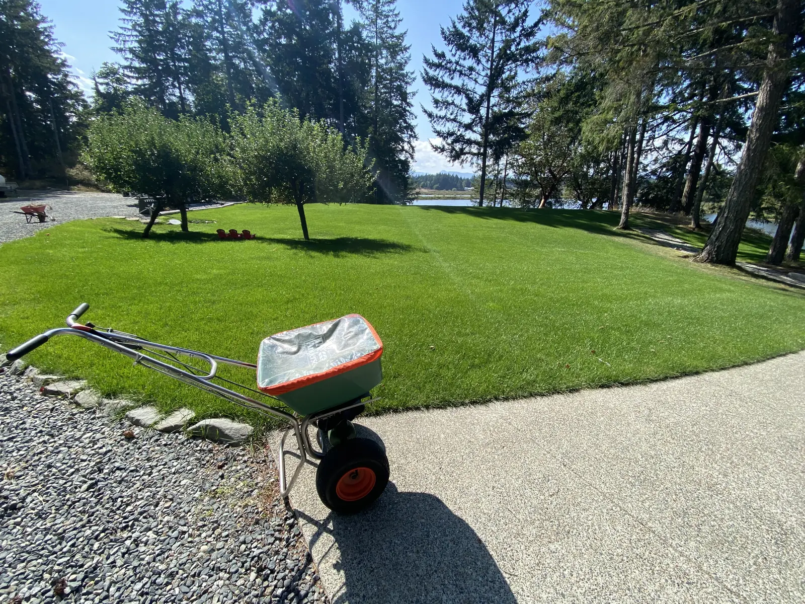 Finished graded lawn with a broadcast spreader on the adjoining driveway