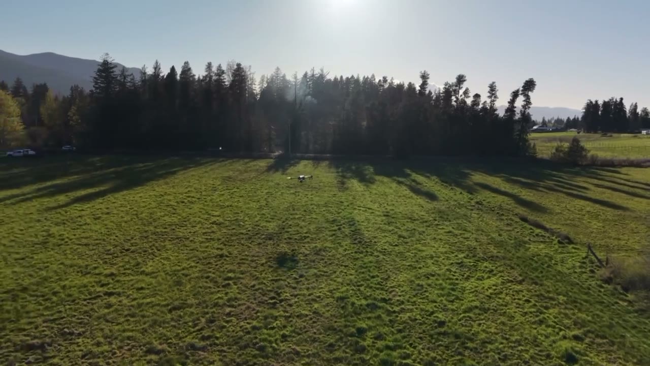 Raincoast seeding drone flying over a green field in BC